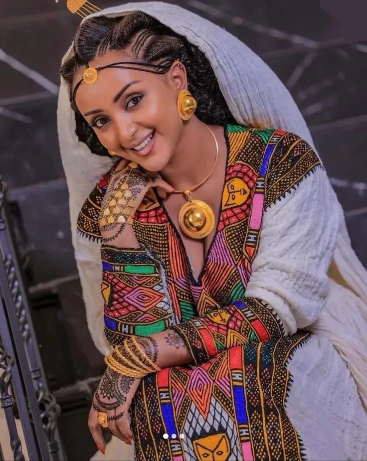 Model wearing a hand-woven Ethiopian habesha kemis with gold jewelry